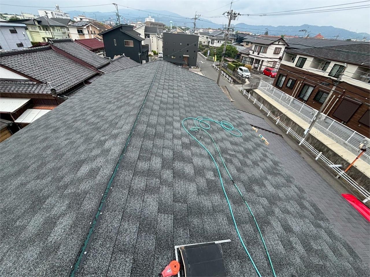 シングル屋根に棟板金を施工している様子